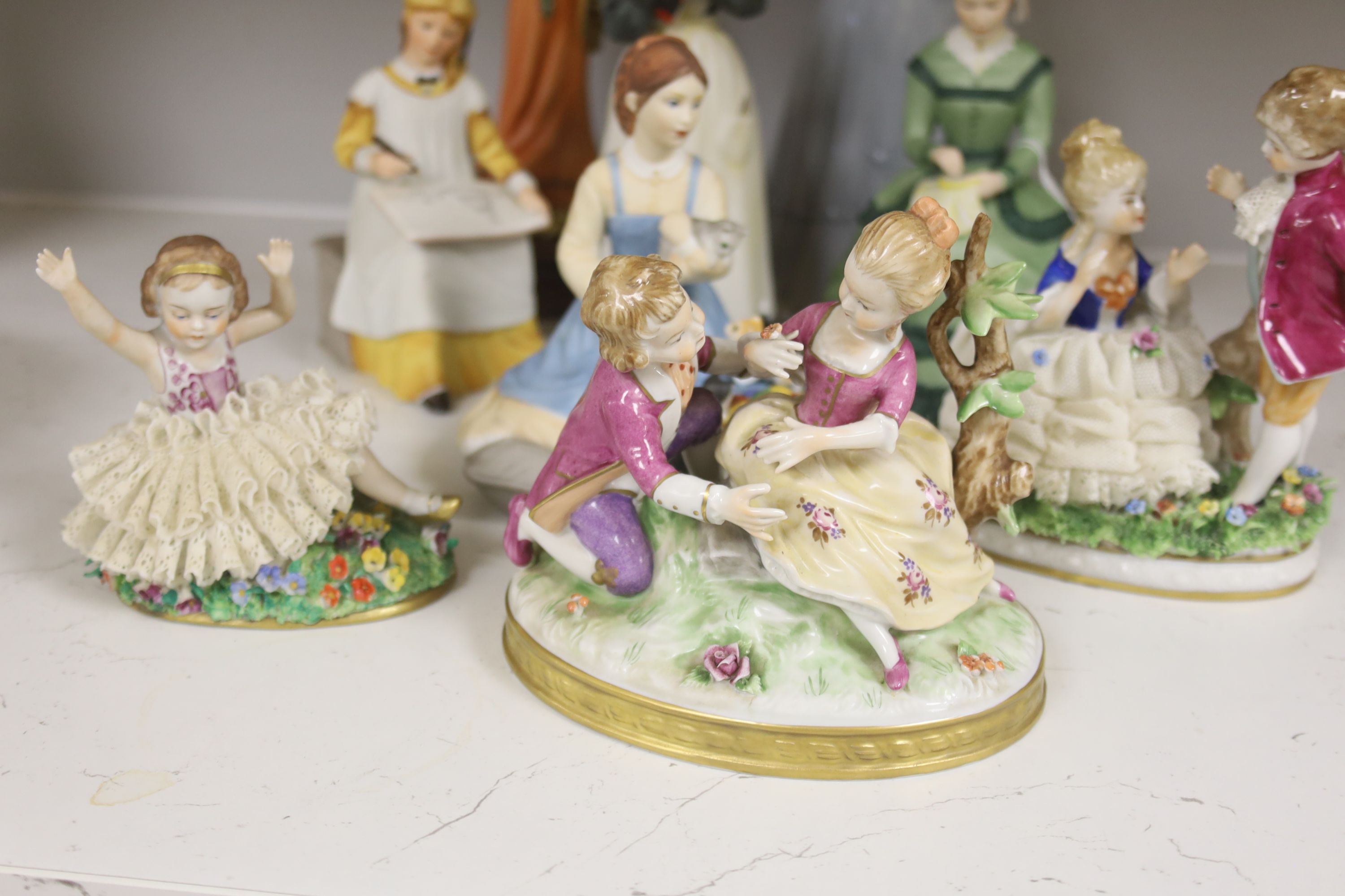 A German porcelain group of two children by a tree stump, on rocky base, two 'crinoline' figures and six other porcelain groups